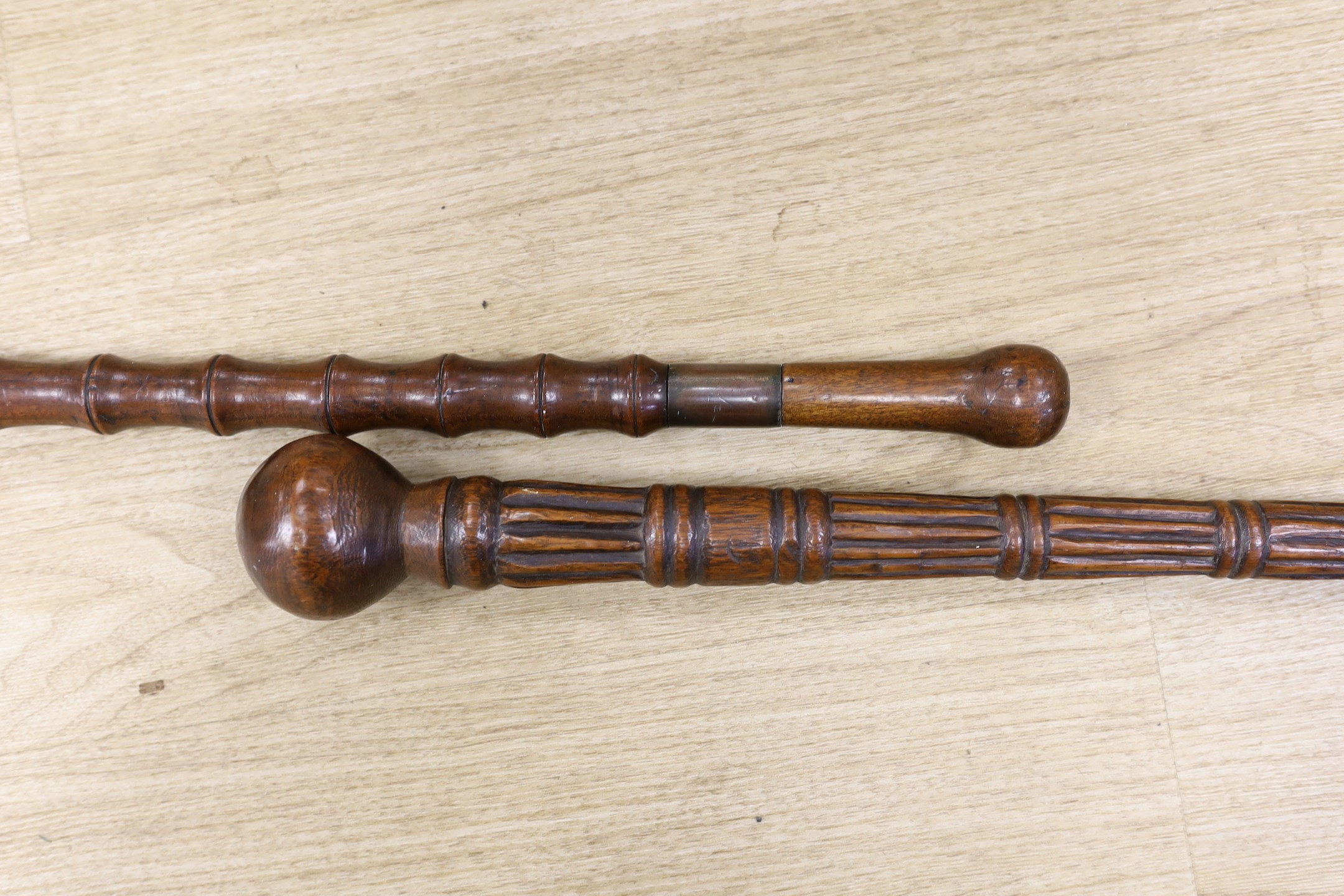 Two carved wood walking sticks, longest 91cms